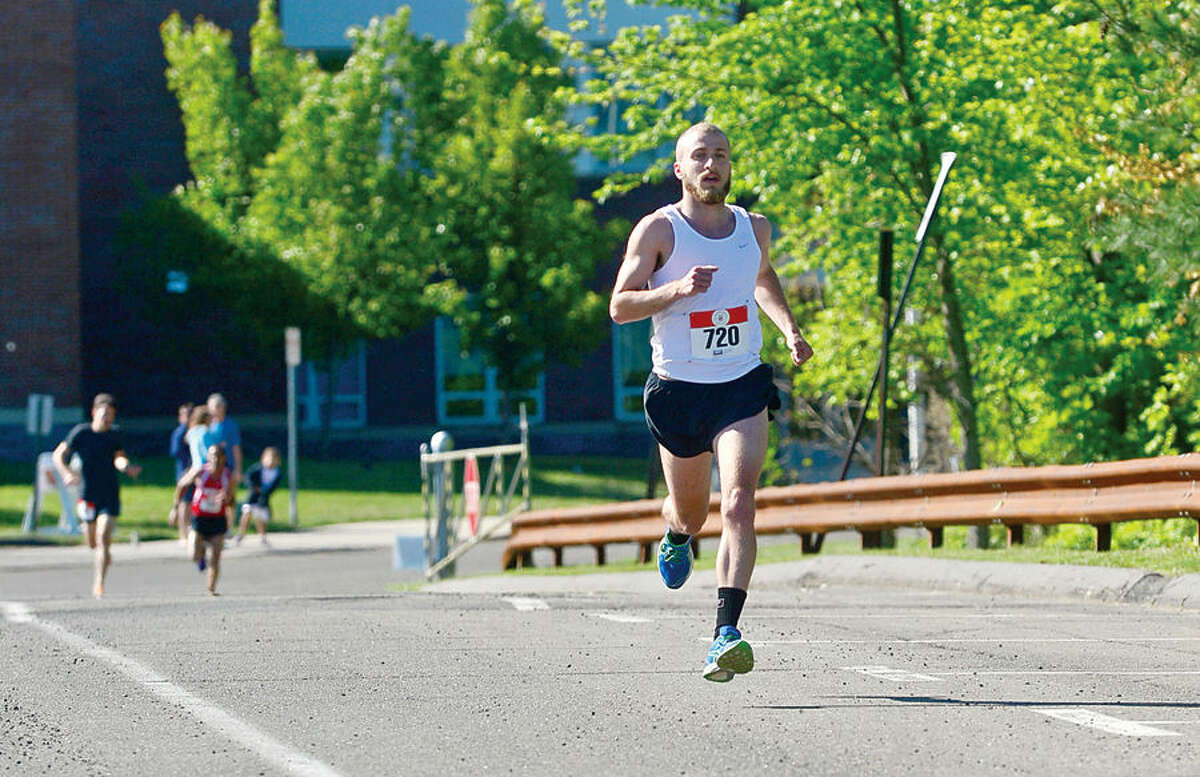 Hour photo / Erik Trautmann James Bloom finishes first in the annual Weston Memorial Day 5k Road Race Saturday.