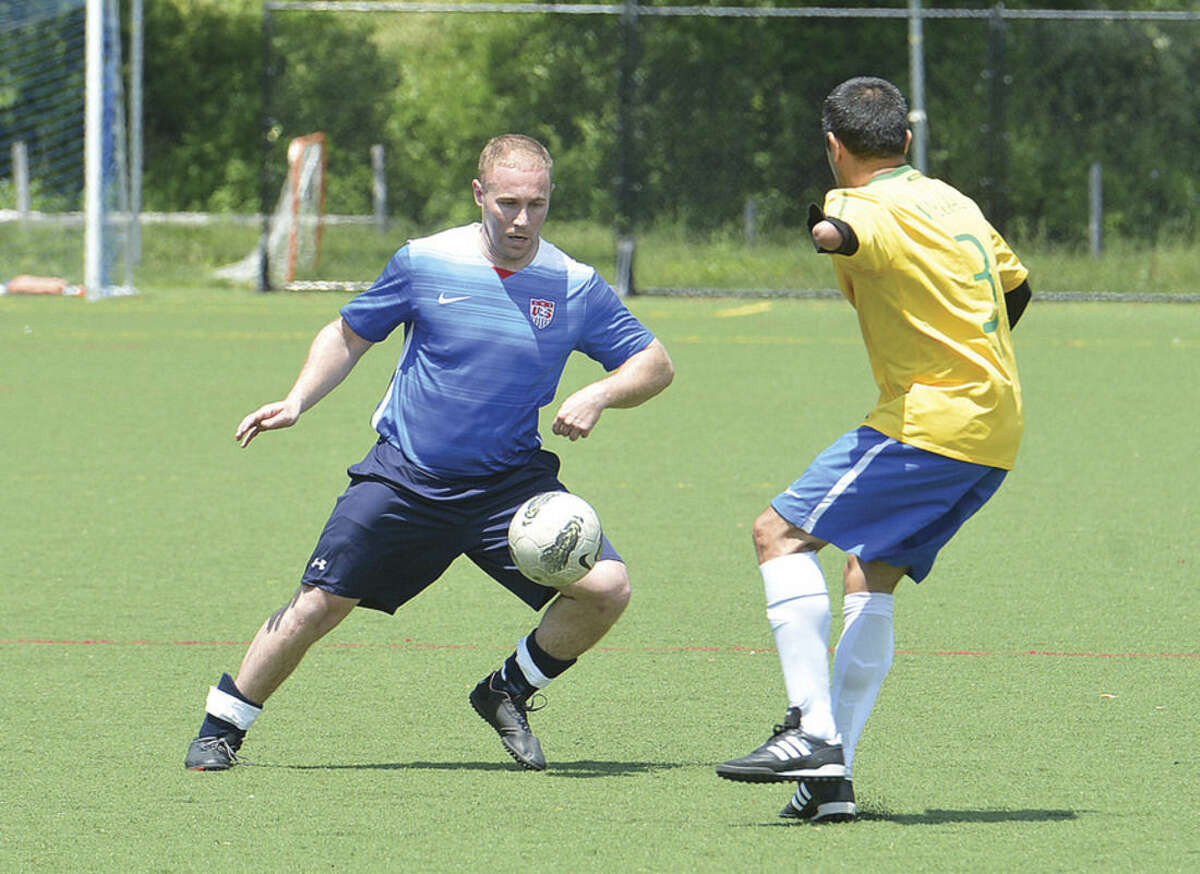 Hour photo/Alex von Kleydorff Wilton Blue's Tom Thresher, left, makes a move against the Ancient Warriors during Monday's game in the ninth annual Memorial Soccer Challenge to benefit Kick For Nick at Lilly Field in Wilton.