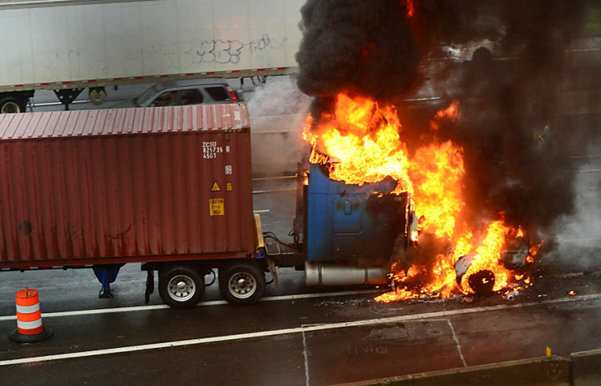 Hour photo / Erik Trautmann Norwalk firefighters fight a tractor trailer fire on I-95 Southbound at exit 14 Thursday morning