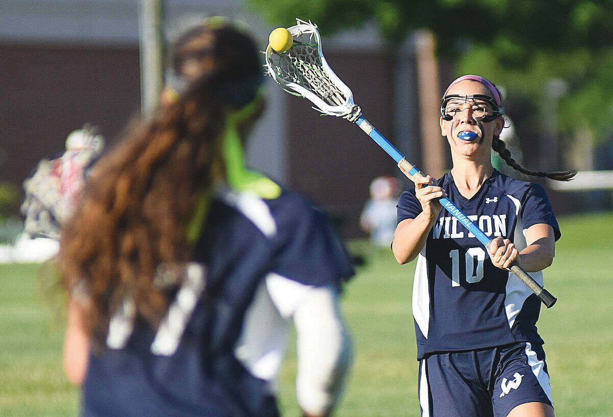 Wilton's Lilla Seymour, right, passes off the ball to teammate Laine Parsons during Thursday's Class L quarterfinal game at Glastonbury.