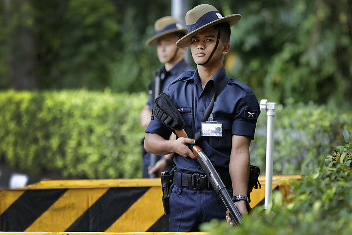 Singapore Gurkha policemen guard the grounds surrounding the venue of the 14th International Institute for Strategic Studies Shangri-la Dialogue, or IISS, Asia Security Summit, Sunday, May 31, 2015, in Singapore. Police stepped up security around the venue of the international security conference Sunday following a shootout at a roadblock in which officers fatally shot one man and detained two others. The security conference, a major event in the Asia-Pacific region attended by U.S. Secretary of Defense Ash Carter and delegates from dozens of countries from around the world, was uninterrupted but access to the venue was restricted. (AP Photo/Wong Maye-E)