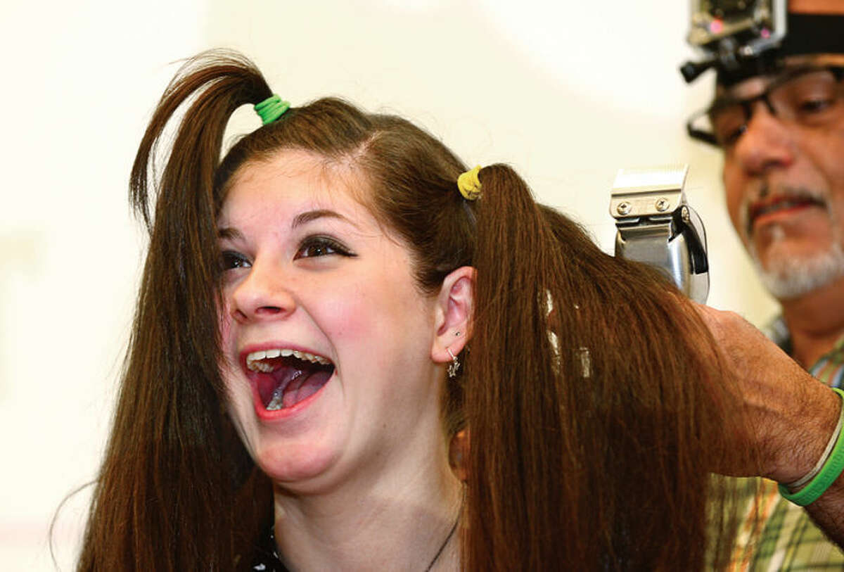 Hour photo / Erik Trautmann Jennifer Pohl, a Norwalk High School sophomore, has her head shaved in the school's Public Forum Room Friday morning to benefit cancer research. Pohl has raised $660 dollars so far for the St. Baldrick's Organization to help fight cancer.