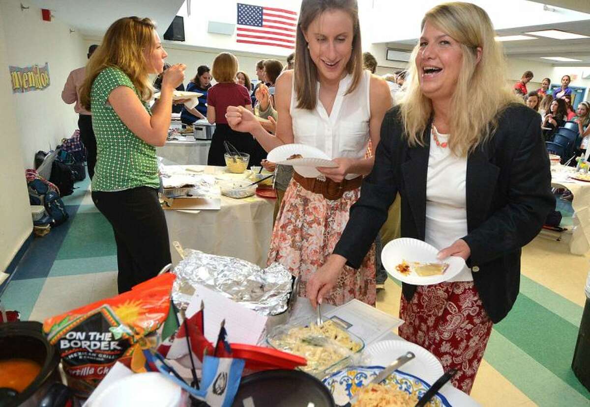 Teachers Joanna Cloherty and Jenifer Dunn sample a chicken marbella during the World Language Week food festival at Middlebrook School.