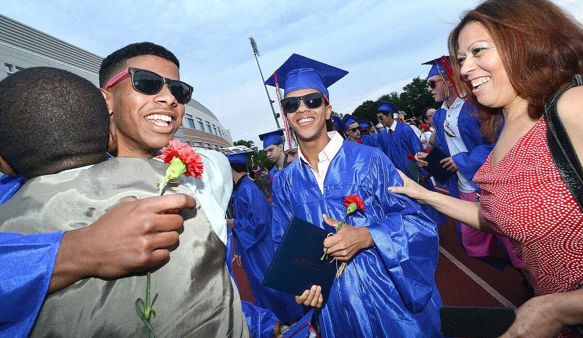 Hour Photo/Alex von Kleydorff Pierre Page and Loida Diaz greet Jose Peralto and Robert Diaz as they cross the 'M' and graduate from Brien McMahon High School