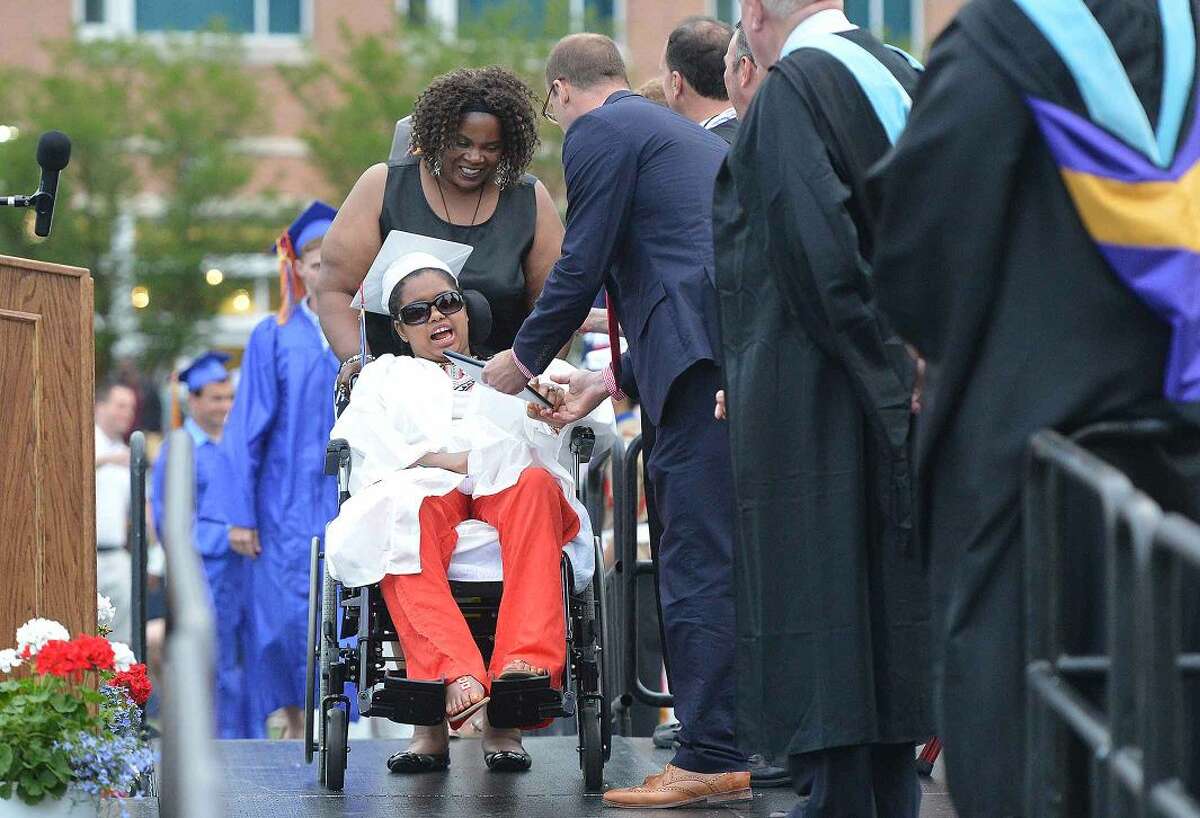 Hour Photo/Alex von Kleydorff Wheelchair bound after being hit by a car in 2011,Teanna Escourse gets her diploma during the Brien McMahon High School Class of 2015 Commencement Exercises on Wednesday