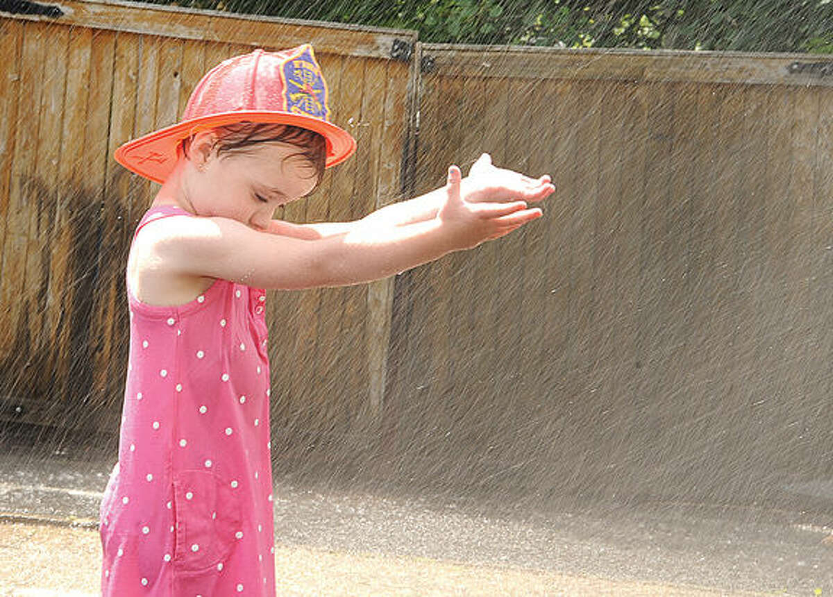 Emma Diamond 3, cools down in the sprinkler Sunday at the Georgetown Day celebration. Photo/Matthew Vinci