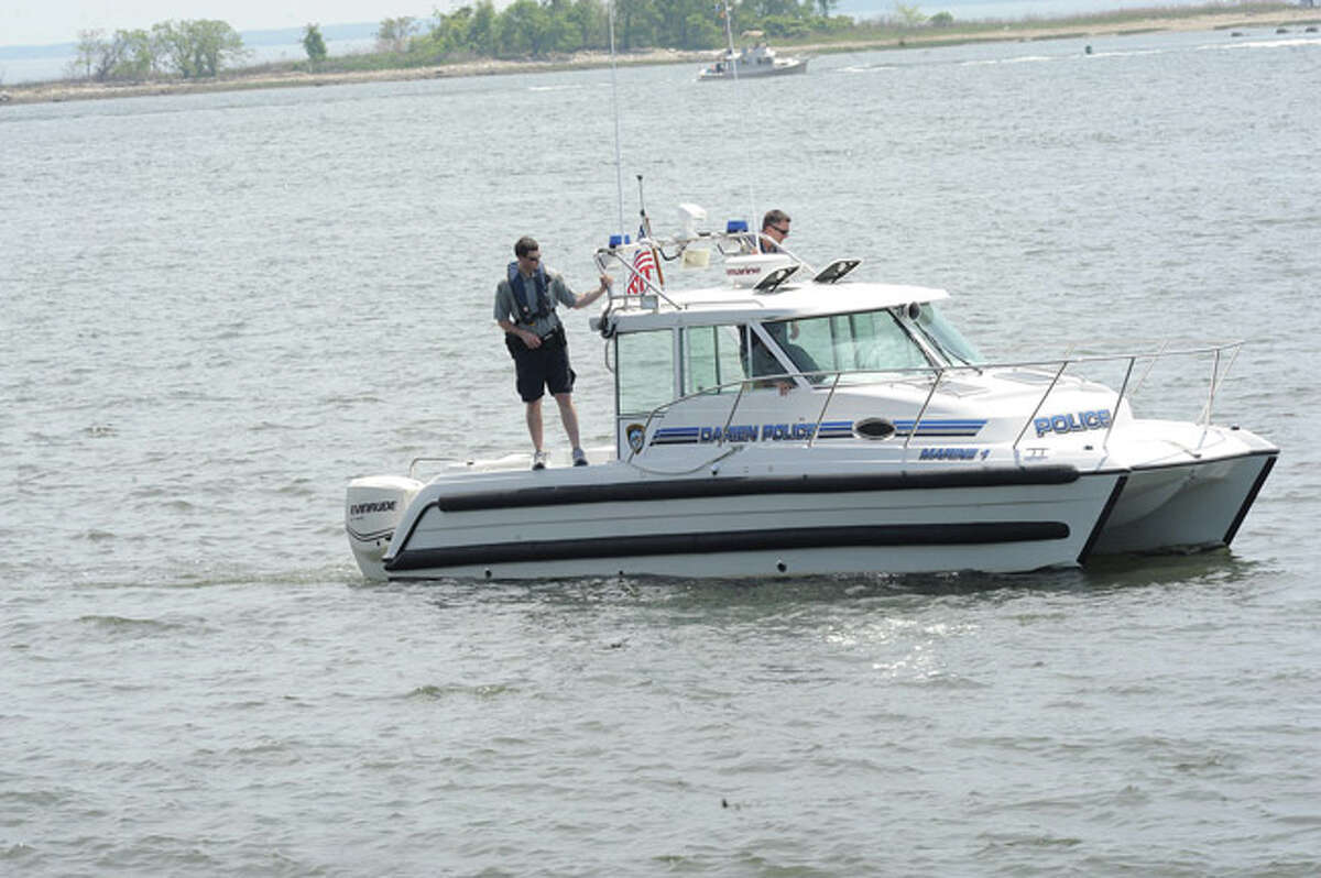 Darien police one of many in the search for a member of a turned over boat missing off the shore at Calf Pature Beach in Norwalk. Hour photo/Matthew Vinci