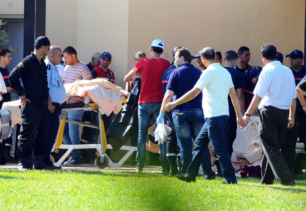 Injured people are treated near the area where an attack took place in Sousse, Tunisia, Friday June 26, 2015. A young man unfurled an umbrella and pulled out a Kalashnikov, opening fire on European sunbathers in an attack that killed at least 28 people at a Tunisian beach resort — one of three deadly attacks from Europe to the Middle East on Friday that followed a call to violence by Islamic State extremists. (AP Photo/Hassene Dridi)