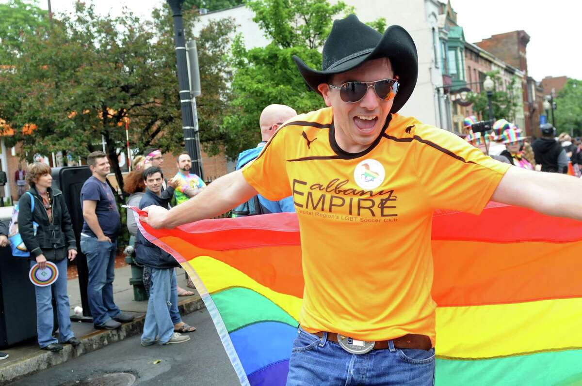 Dan Bollana with Albany Empire LGBT Soccer Club, right, uses his flag as a cape in the Capital PRIDE Parade on Saturday, June 11, 2016, in Albany, N.Y. The annual parade, festival and rally celebrates the Lesbian, Gay, Bisexual, Transgender and Queer community with entertainment and family-friendly activities. (Cindy Schultz / Times Union)