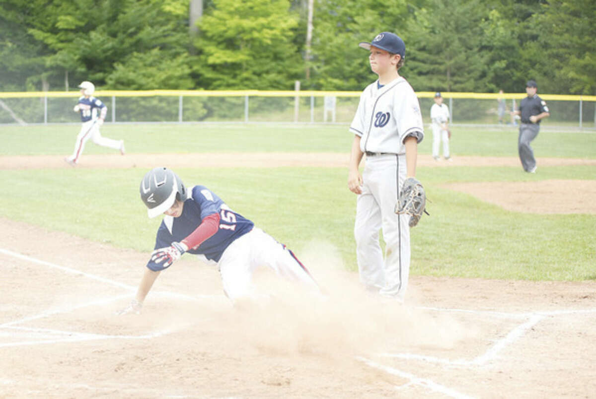 Hour photo/Danielle Calloway Norwalk's Alistair Morin, slides into home safely against Wilton on Monday.