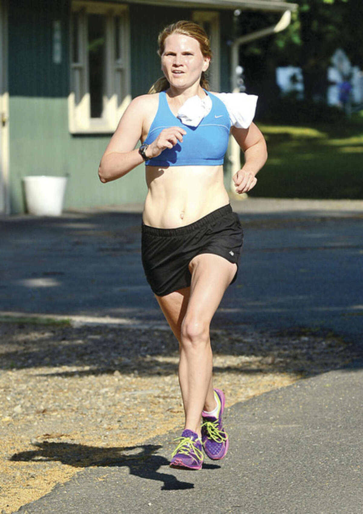 Hour photo / Erik Trautmann Kate Pfeffer finishes first for the women in the 3.1 mile race during the Westport Road Runners Summer Series Saturday at Longshore Park.