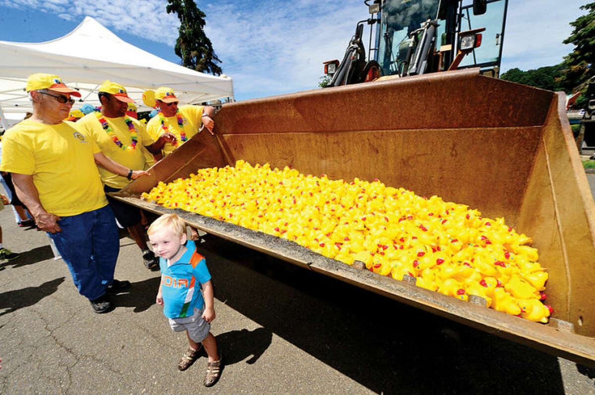 Hour photo / Erik Trautmann 2 year old James Scmidt poses near 2,500 rubber duckie entrants in the Westport Sunrise Rotary's annual Great Duck Race event at the Saugatuck River in downtown Westport Saturday.