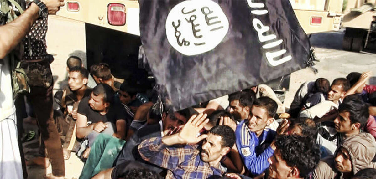 This image posted on a militant website on Saturday, June 14, 2014, which has been verified and is consistent with other AP reporting appears to show militants from the al-Qaida-inspired Islamic State of Iraq and the Levant (ISIL) with captured Iraqi soldiers wearing plain clothes after taking over a base in Tikrit, Iraq. The Islamic militant group that seized much of northern Iraq has posted photos that appear to show its fighters shooting dead dozens of captured Iraqi soldiers in a province north of the capital Baghdad. Iraq's top military spokesman Lt. Gen. Qassim al-Moussawi confirmed the photos?’ authenticity on Sunday and said he was aware of cases of mass murder of Iraqi soldiers. (AP Photo via militant website)