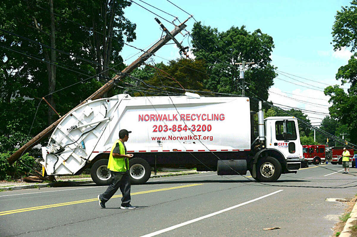 Hour photo/Erik Trautman A City Carting truck snapped a utility Poole closing Ward St in Norwalk Friday morning.