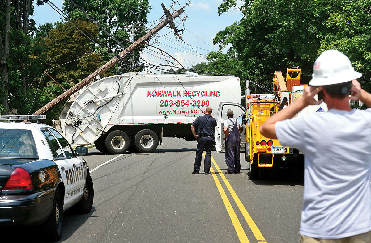 Hour photo / Erik Trautmann A City Carting refuse truck snapped a utility pole closing Ward St in Norwalk Friday monrning.