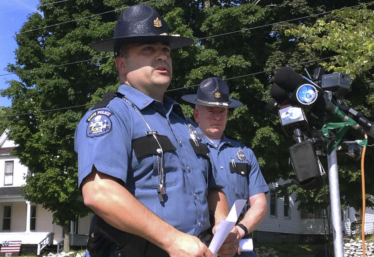 Maine State Police Lt. Sean Hashey, left, speaks Friday, July 17, 2015, outside the police department in Lincoln, Maine. Suspect Anthony Lord was arrested without incident Friday at a family member's home in Houlton, Maine, and faces charges in the shootings of several people overnight several towns in northern Maine. At right is State Police Maj. Chris Grotton. (AP Photo/Alanna Durkin)