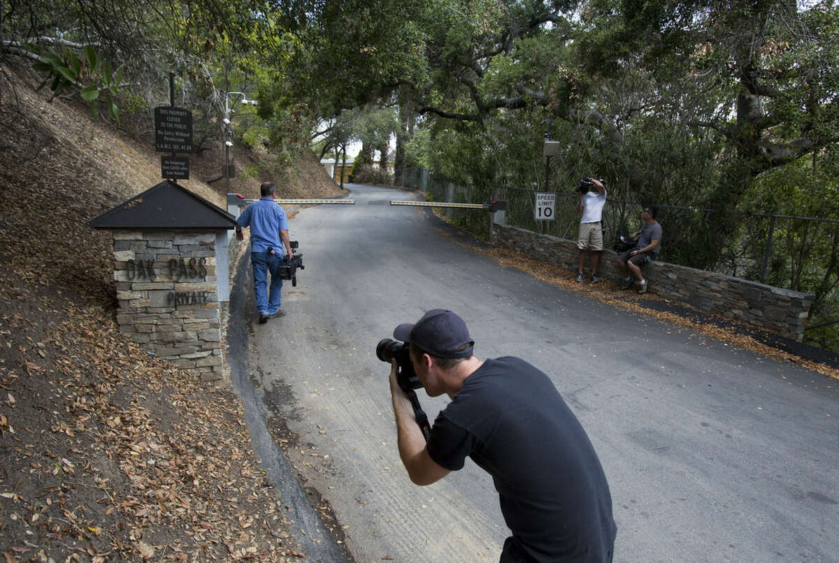A photographer talks photos outside an entrance to to the home of actress Demi Moore, in Beverly Hills, Sunday, July 19, 2015. Coroner’s officials say a 21-year-old man accidentally drowned in the backyard pool of a Los Angeles home owned by actress Demi Moore. (AP Photo/Ringo H.W. Chiu)