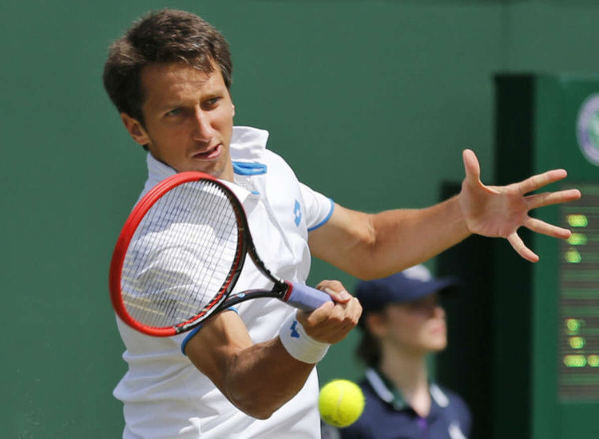 Sergiy Stakhovsky of Ukraine plays a return to Ernests Gulbis of Latvia during their men's single match at the All England Lawn Tennis Championships in Wimbledon, London, Wednesday, June 25, 2014. (AP Photo/Ben Curtis)