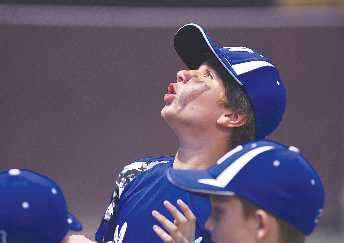 Hour photo/John Nash - Norwalk Cal Ripken 9-year-old All-Star Charlie LaFreniere looks skyward as the clouds darken and rain starts to fall during a pre-game rain delay at Tuesday's State Tournament game in Milford.
