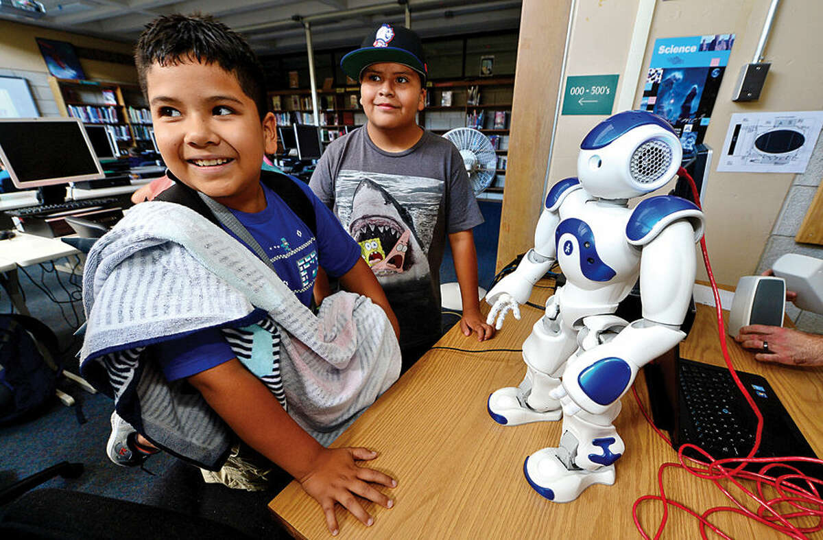 Hour photo / Erik Trautmann Norwalk Public Schools Personal Fulfillment (PF) Campers, Frank Escalante and George Diaz, both 10, watch a demonstration of the Westport Library's NAO humanoid robot, Vincent, during a visit to Norwalk High School byy the library's digital experience team Thursday afternoon.