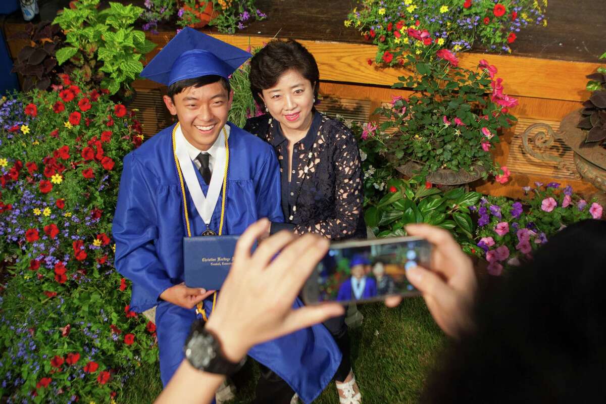 Anna Yoon sits with son, David Yoon, for a photograph after the Thirty-Third Commencement Exercises of Christian Heritage School in Trumbull, Conn. on Saturday, June 11, 2016.
