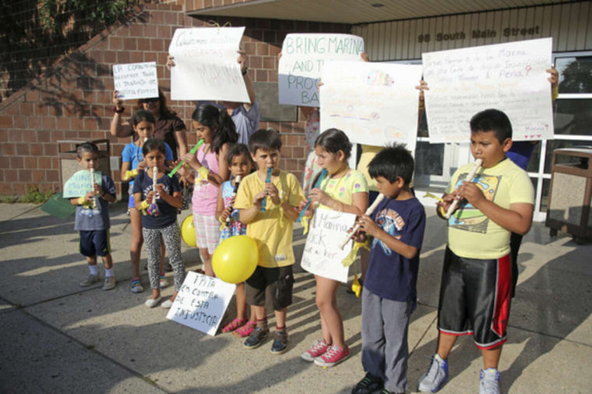 Children play music and hold signs outside of the South Norwalk Community Center, Inc., over termination of Marina Forero-Ferrandino as executive director by board Chairman Warren A. Pena. Hour Photo / Danielle Calloway