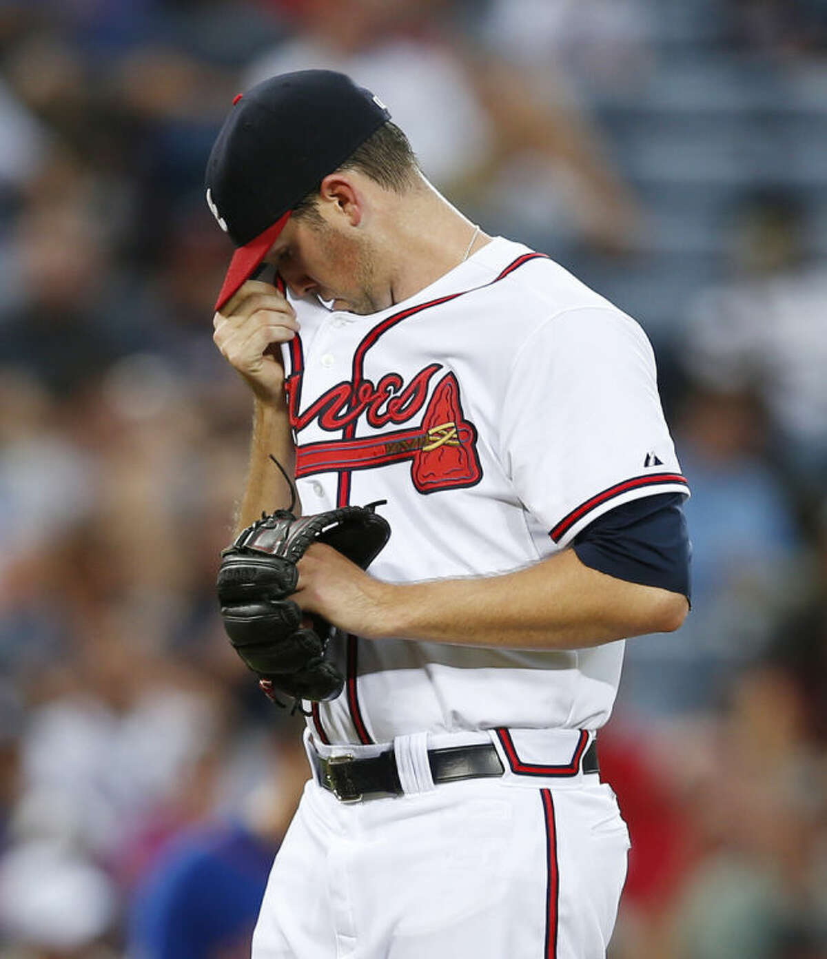 Atlanta Braves pitcher Alex Wood (40) wipes his face after loading the bases in the third inning of a baseball game against the New York Mets in Atlanta, Monday, June 30, 2014. (AP Photo/John Bazemore)