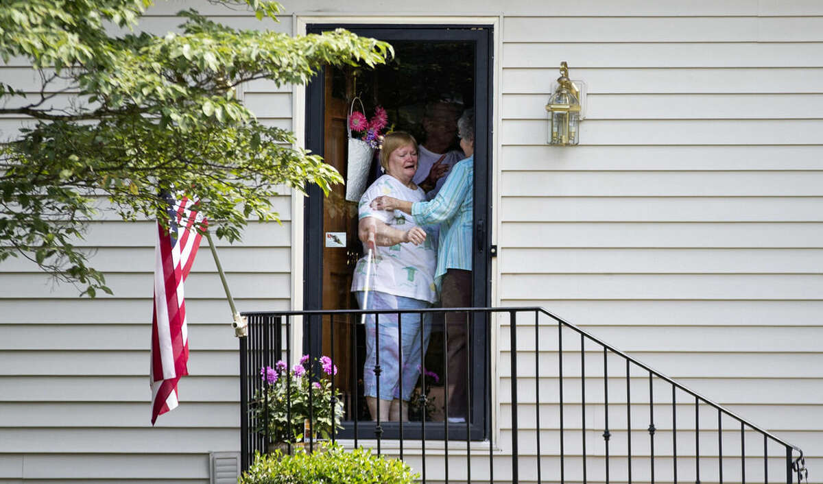 A woman answers the door as mourners visit the home of Cathy Wells, the mother of Skip Wells, one of the four Marines killed in Thursday's shooting in Chattanooga, Tenn., Friday, July 17, 2015, in Marietta, Ga. (AP Photo/David Goldman)