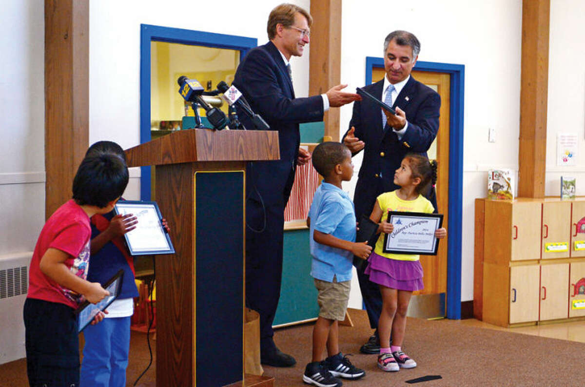 Merrill Gray, executive director of the CT Early Childhood Alliance, presents state Sen. Carlo Leone (D-27) with a Children's Champions award in recognition of early childhood legislative initiatives during a press conference Wednesday at Childcare Learning Centers in Stamford.
