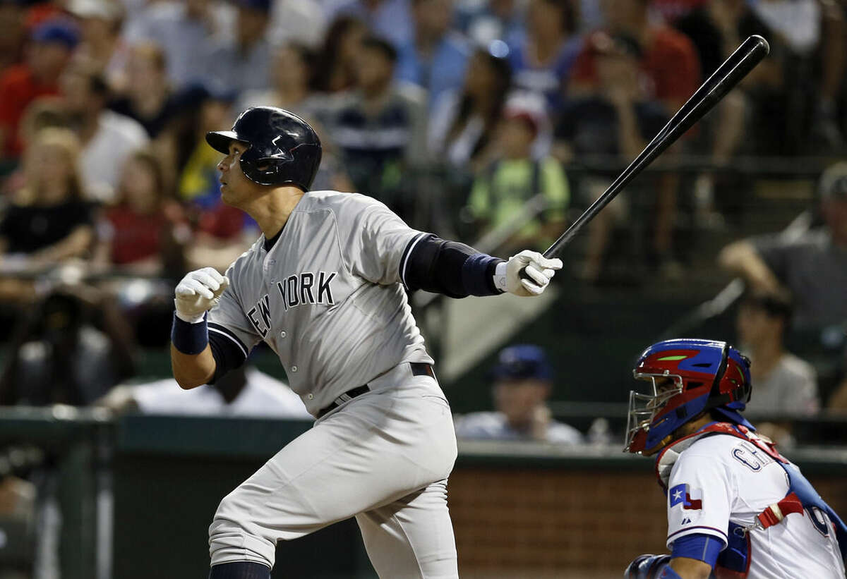 New York Yankees' Alex Rodriguez follows through on a solo home run swing off a pitch from Texas Rangers' Matt Harrison as Rangers catcher Robinson Chirinos watches in the sixth inning of a baseball game Monday,July 27, 2015, in Arlington, Texas. (AP Photo/Tony Gutierrez)