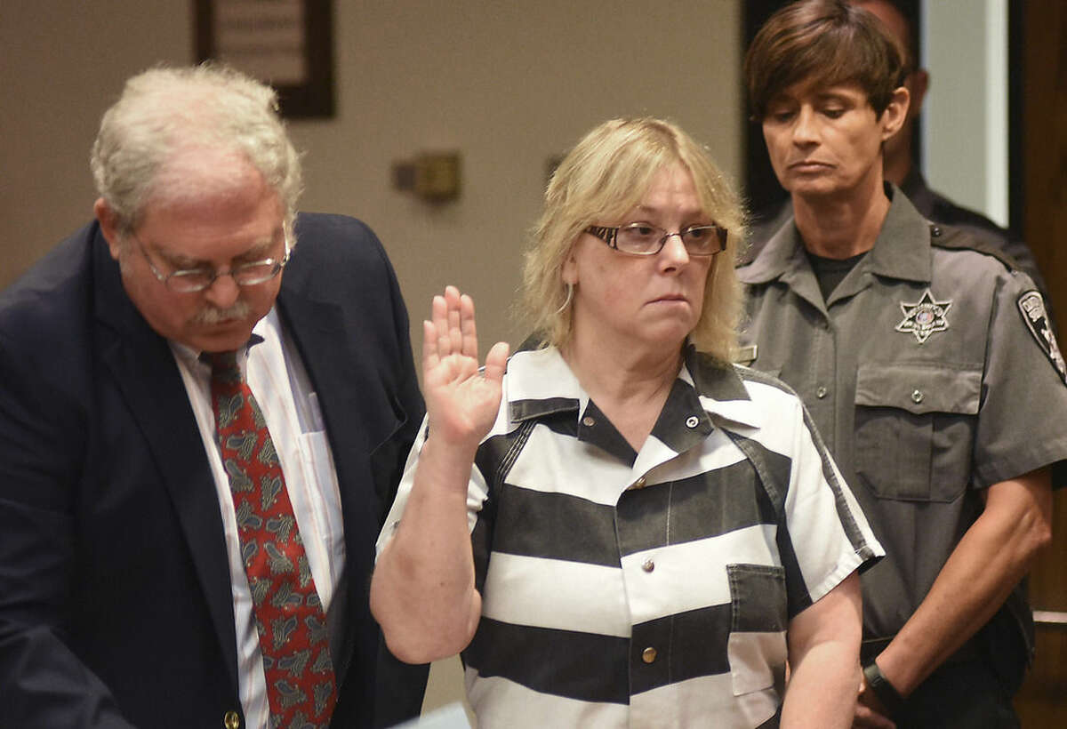 Joyce Mitchell raises her hand during a court appearance with her attorney Stephen Johnston on Tuesday July 28, 2015 in Plattsburgh, N.Y. Mitchell, an instructor in the tailor shop at the Clinton Correctional Facility, pleaded guilty to charges of aiding two inmates convicted of murder by smuggling hacksaw blades and other tools to the pair, who broke out and spent three weeks on the run in June. She faces a sentence of 2 1/3 to 7 years in prison under terms of a plea deal with prosecutors. (Rob Fountain/The Press-Republican via AP, Pool)