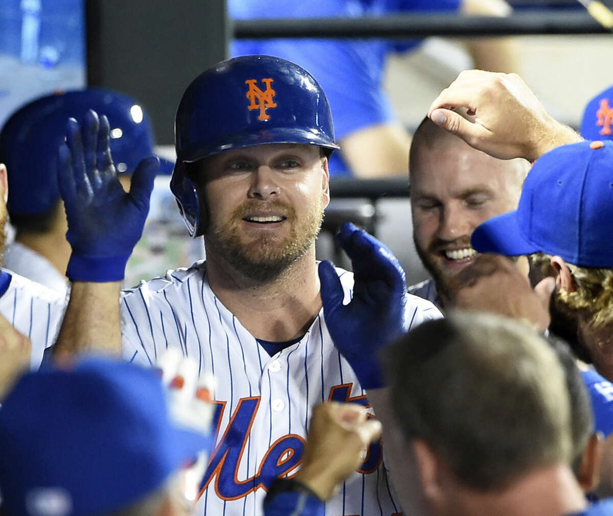 New York Mets' Lucas Duda is congratulated by teammates in the dugout after hitting his second home run of a baseball game against the Washington Nationals in the seventh inning at Citi Field on Saturday, Aug. 1, 2015, in New York. (AP Photo/Kathy Kmonicek)