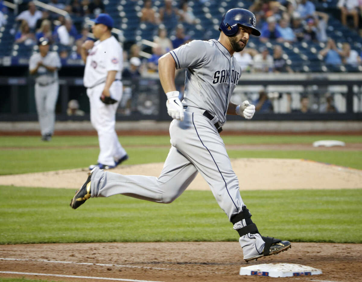 San Diego Padres Yonder Alonso, right, runs over first base after hitting a third-inning solo home run off New York Mets starting pitcher Bartolo Colon, center, in a baseball game in New York, Wednesday, July 29, 2015. (AP Photo/Kathy Willens)