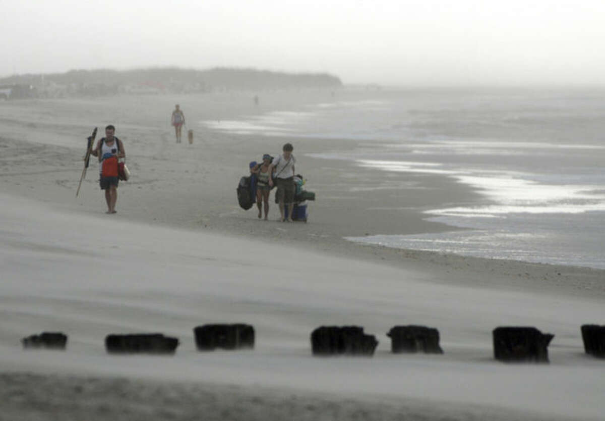 Clouds and rains move in as beachgoers leave Freeman Park at the north end of Carolina Beach, N.C., Thursday, July 3, 2014. Residents along the coast of North Carolina are bracing for the arrival of the Hurricane Arthur, which threatens to give the state a glancing blow on Independence Day. (AP Photo/Wilmington Star-News, Mike Spencer)