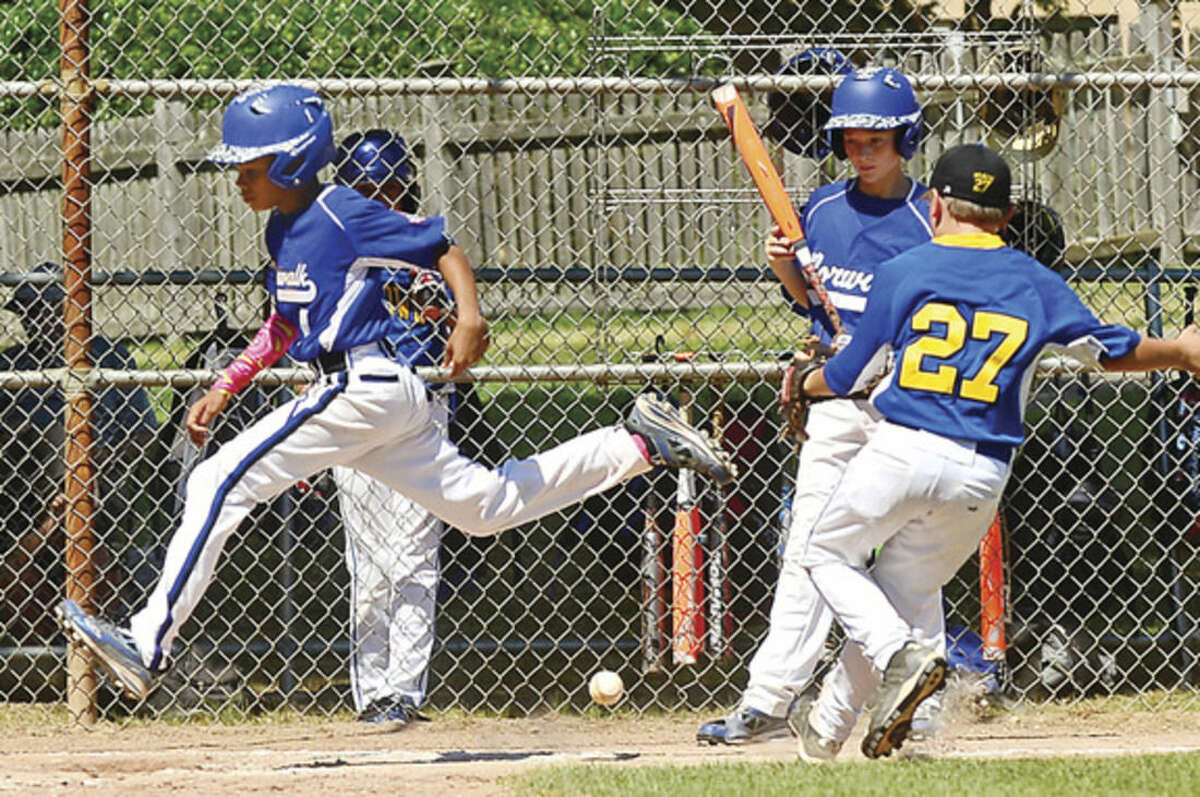 Hour photo/Erik Trautmann Norwalk's AJ Robinson crosses the plate during the Cal Ripken 11s state championship win over Newtown on Saturday.