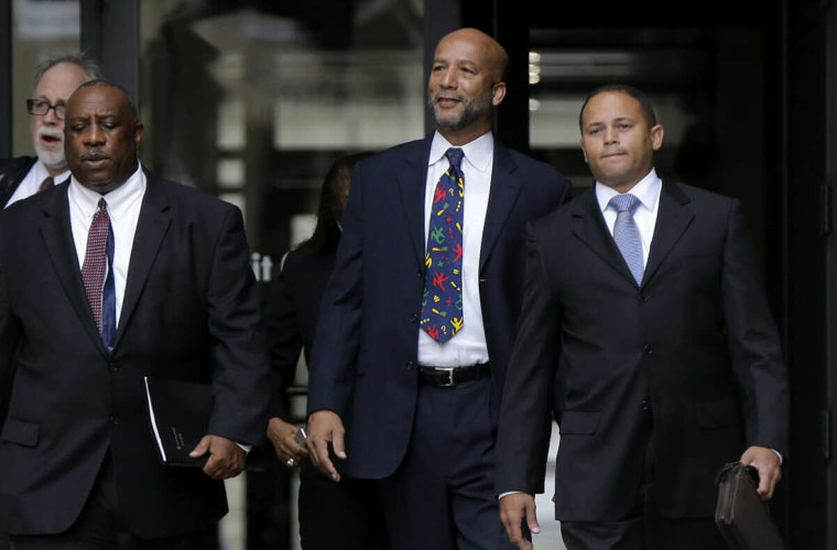 Former New Orleans Mayor Ray Nagin, center, leaves federal court after being sentenced in New Orleans, Wednesday, July 9, 2014. Nagin was sentenced to 10 years in prison for bribery, money laundering and other corruption that spanned his two terms as mayor, including the chaotic years after Hurricane Katrina hit in 2005. He was convicted Feb. 12 of accepting hundreds of thousands of dollars from businessmen who wanted work from the city or Nagin's support for various projects. The bribes came in the form of money, free vacations and truckloads of free granite for his family business. (AP Photo/Gerald Herbert)