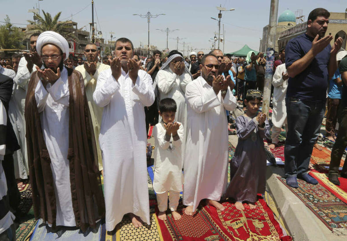 Followers of Shiite cleric Muqtada al-Sadr attend open-air Friday prayers in the Shiite stronghold of Sadr City, Baghdad, Iraq, Friday, July 11, 2014. The lightning sweep by the militants over much of northern and western Iraq the past month has dramatically hiked tensions between the country's Shiite majority and Sunni minority. At the same time, splits have grown between the Shiite-led government in Baghdad and the Kurdish autonomous region in the north. (AP Photo/Karim Kadim)
