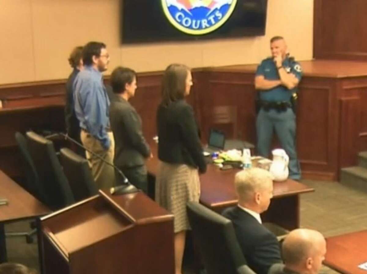 In this image made from Colorado Judicial Department video, James Holmes, second from left in blue shirt, stands with his defense team as Judge Carlos A. Samour, Jr., reads the jury's sentencing verdict in the Colorado theater shooting trial in Centennial, Colo., on Monday, Aug. 3, 2015. (Colorado Judicial Department via AP)