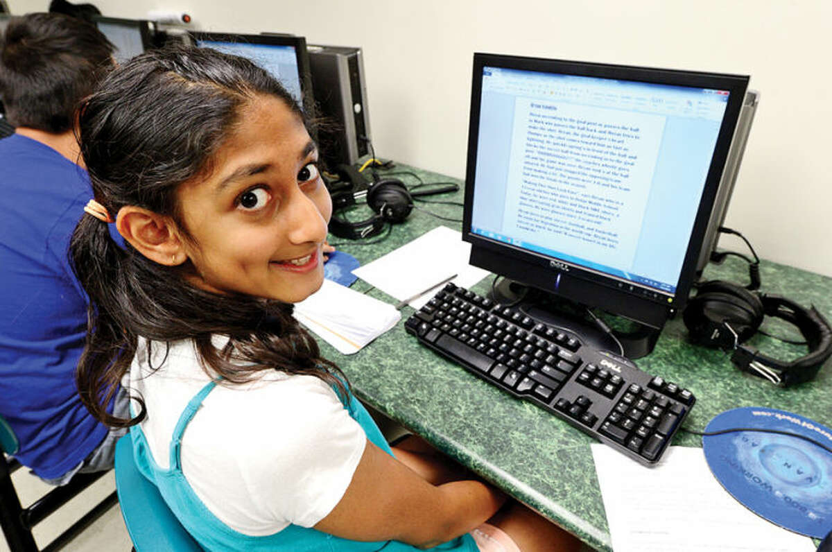 Westhill High School alumni created Project Lede, a summer program that teaches journalism to middle school students, including 11-year-old Arya Bhoghte, during a session at Toquam Magnet School Friday. The program also teaches the middle schoolers how to create a student newspaper.