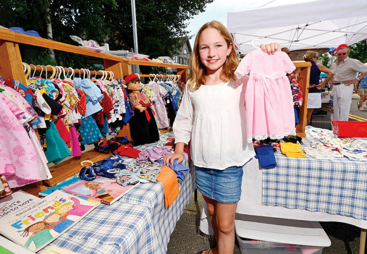 Hour photo / Erik Trautmann Grace Cristini, 10, pick out a dress for her doll during the 3rd annual Wilton Street Fair and Sidewalk Sale in Wilton Center Saturday.