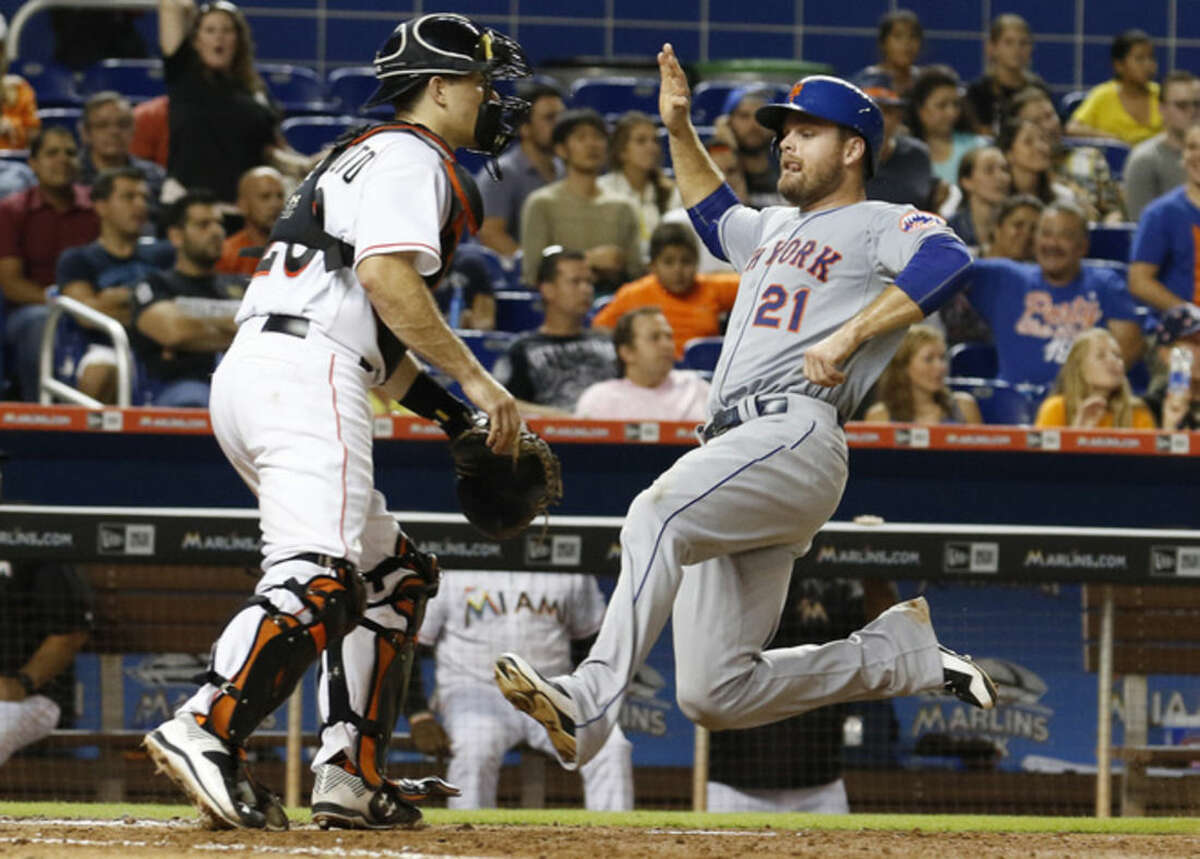 New York Mets first baseman Lucas Duda runs to home plate to score on a single by Eric Campbell in the eighth inning as Miami Marlins catcher J.T. Realmuto waits for the late throw during a baseball game in Miami, Tuesday Aug. 4, 2015. (AP Photo/Joe Skipper)