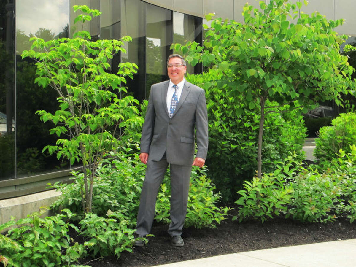 In this June 26, 2014 photo, Ken Parker, native plant consultant for the Seneca Indian Nation, poses outside the William Seneca administration building on the Cattaraugus Reservation in western New York. Parker is helping to implement the Senecas' new policy of using only indigenous plants in public landscaping on Seneca territories as a way to preserve culture and the environment. (AP Photo/Carolyn Thompson)