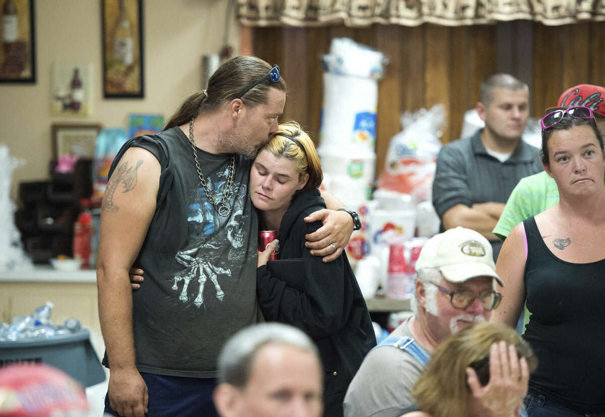 James Logan and his wife Lisa embrace during a community meeting for evacuees as a wildfire burns near Clearlake, Calif., Tuesday, Aug. 4, 2015. Firefighters made some progress Tuesday afternoon with some help from light rain that fell in the area. (AP Photo/Josh Edelson)