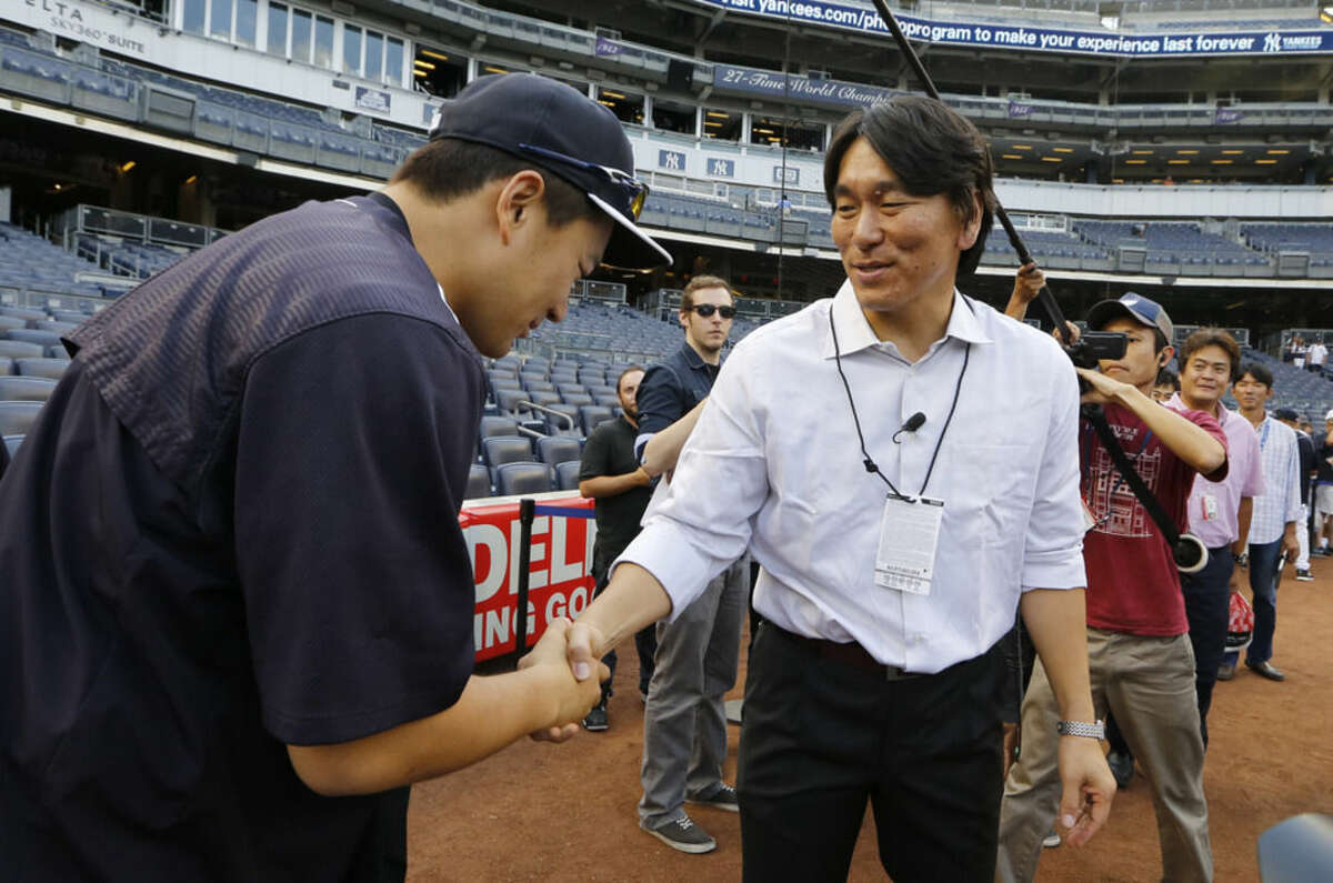 New York Yankees starting pitcher Masahiro Tanaka, left, greets former Yankee Hideki Matsui before a baseball game between the Boston Red Sox and the Yankees, Wednesday, Aug. 5, 2015, at Yankee Stadium in New York. Matsui was the 2009 World Series Most Valuable Player. (AP Photo/Kathy Willens)