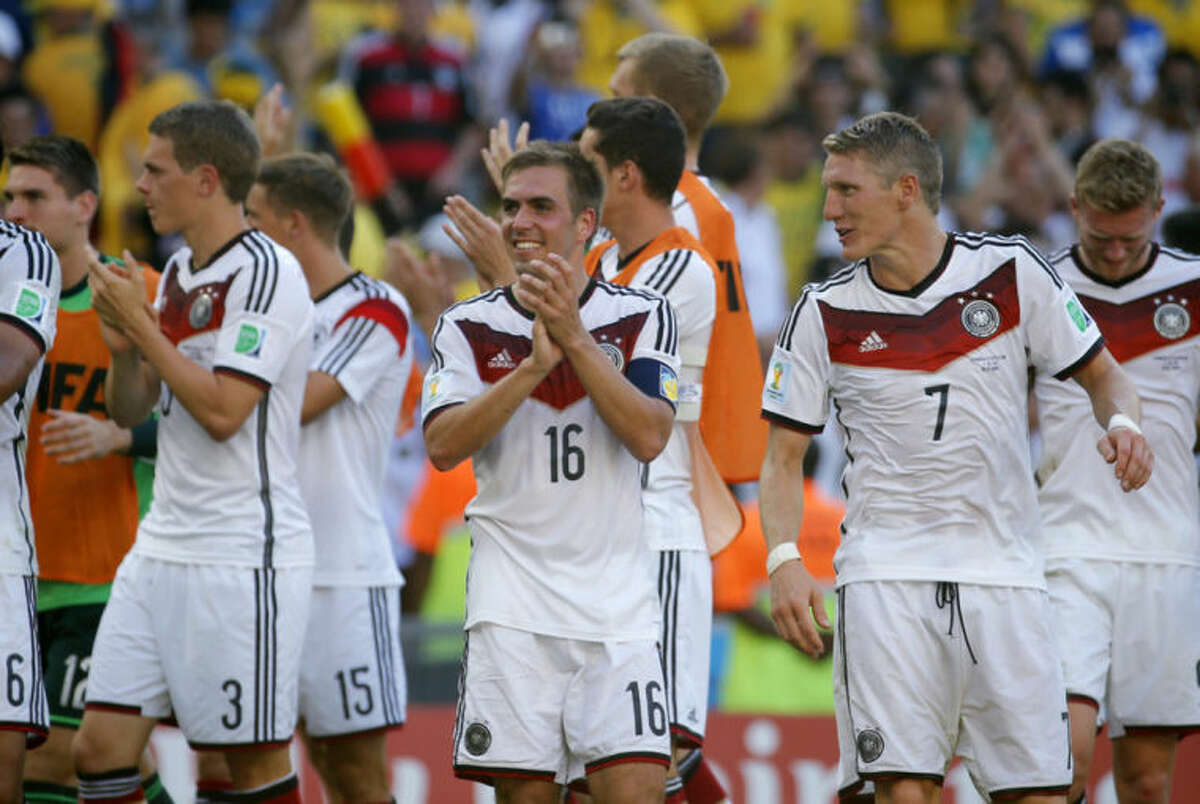 Germany's Philipp Lahm, center, smiles at the end of the World Cup quarterfinal soccer match between Germany and France at the Maracana Stadium in Rio de Janeiro, Brazil, Friday, July 4, 2014. Germany won the match 1-0. . (AP Photo/David Vincent)