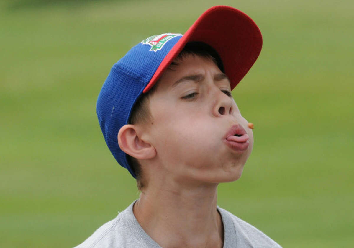 Zach Wendt, 12, from Naperville, Ill., participates in the 41st International Cherry Pit-Spitting Championship on Saturday, July 5, 2014, at Tree-Mendus Fruit Farm in Eau Claire, Mich. Wendt finished first in his age division. (AP Photo/The Herald-Palladium, Don Campbell)