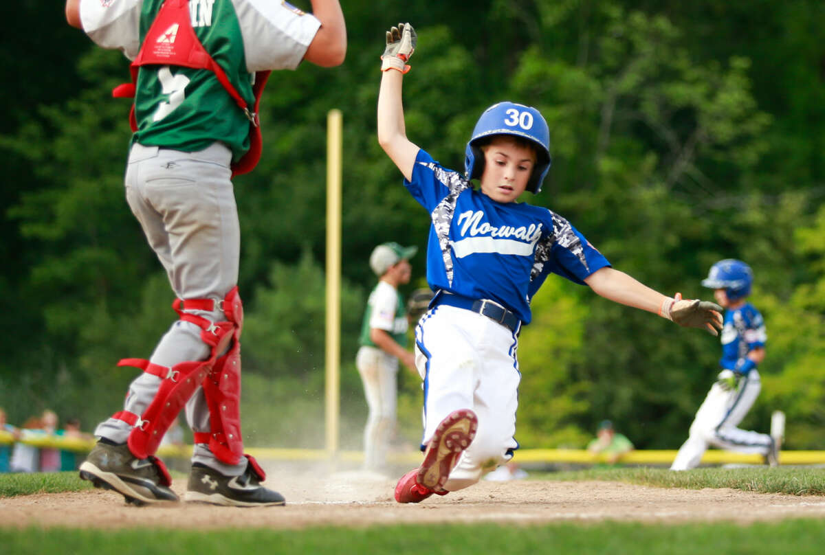Hour photo/Chris Palermo. Will Stalzer slides safely into home plate during Norwalk's 11-1 win over Dover, N.H. in the 2015 New England 9U Regional Championship at Burnt Hill Park in Hebron, Conn. Thursday night.