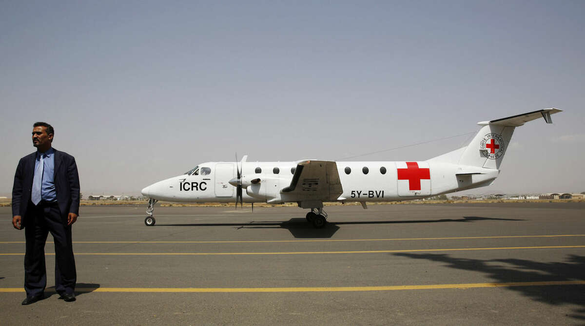 A Yemeni airport security official stands by a plane of the International Committee of the Red Cross on the tarmac of the international airport in Sanaa, Yemen, Saturday, Aug. 8, 2015. (AP Photo/Hani Mohammed)