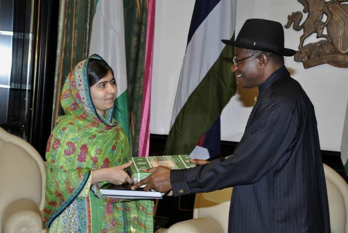 Pakistani activist Malala Yousafzai, left, receives a gift from Nigerian President, Goodluck Jonathan, right, at the Presidential villa, in Abuja, Nigeria, Monday, July 14, 2014. Yousafzai on Monday won a promise from Nigeria?’s leader to meet with the parents of some of the 219 schoolgirls held by Islamic extremists for three months. Malala celebrated her 17th birthday on Monday in Nigeria with promises to work for the release of the girls from the Boko Haram movement. (AP Photo)