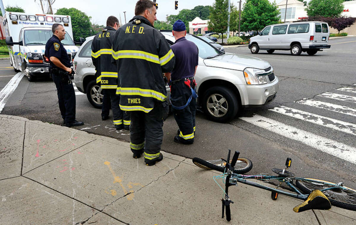 Hour photo / Erik Trautmann Emergency personnel respond to 100 Westport Ave where a bicyclist was struck by a motor vehicle shortly after eight Tuesday monring.